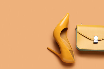 Stylish yellow high heel and purse on brown background