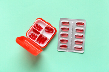 Plastic container and blister pack with pills on color background