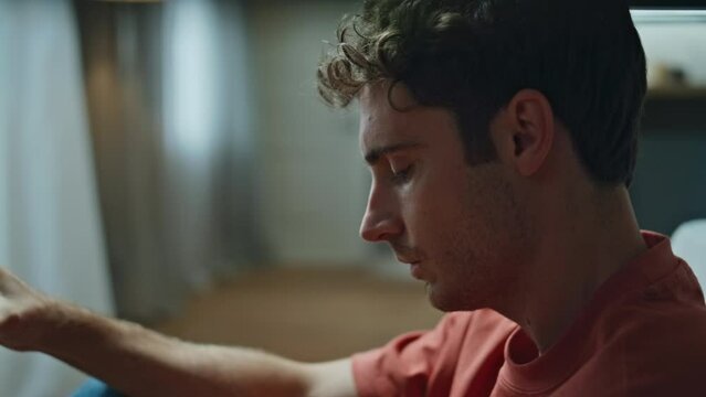 Heartbroken man drinking cognac glass at empty flat closeup. Alcoholic suffering
