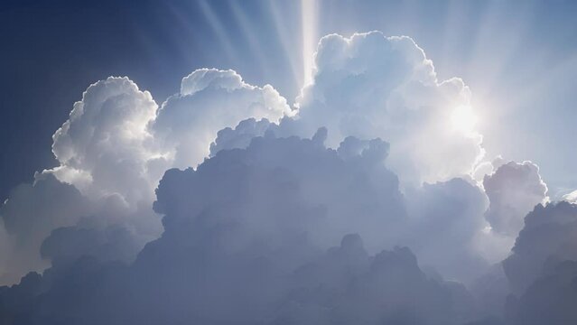 The suns rays create a spotlight effect on a towering cumulus cloud.
