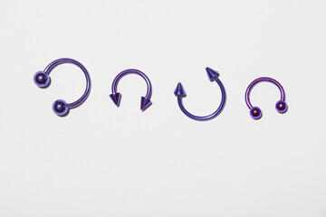 Set of colorful circular barbells for piercing on light background