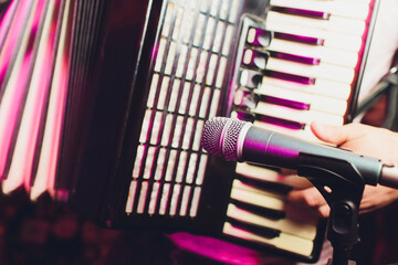 The musician plays the accordion close-up microphone.