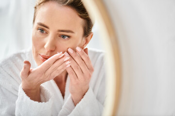 beautiful woman in white comfortable bathrobe wearing her contact lenses near mirror in bathroom
