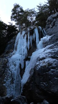 Frozen Waterfall and Water Cascading over the Rocks in Winter