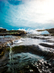 Blue sky with water falling on the rocks at Praia da Pipa - Rio Grande do Norte, Brazil