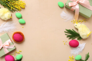 Frame made of Easter eggs, gifts, chickens and mimosa on beige background