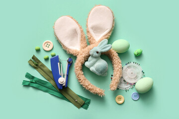 Bunny ears with Easter eggs and tailor supplies on turquoise background