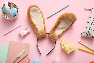 Bunny ears with Easter eggs and stationery on pink background