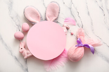 Bunny ears with Easter eggs, gift and blank greeting card on white marble background