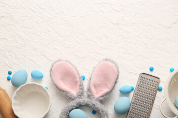 Bunny ears with Easter eggs and cooking utensils on white grunge background