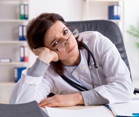Aged female doctor working in the clinic