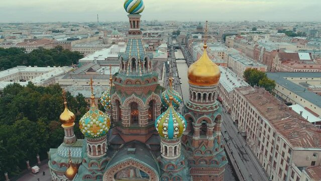 SAINT-PETERSBURG, RUSSIA - JUNE, 2023: Close-up aerial drone view of of the Church on Spilled Blood in Saint Petersburg. Beautiful domes and golden church cross on sunset.