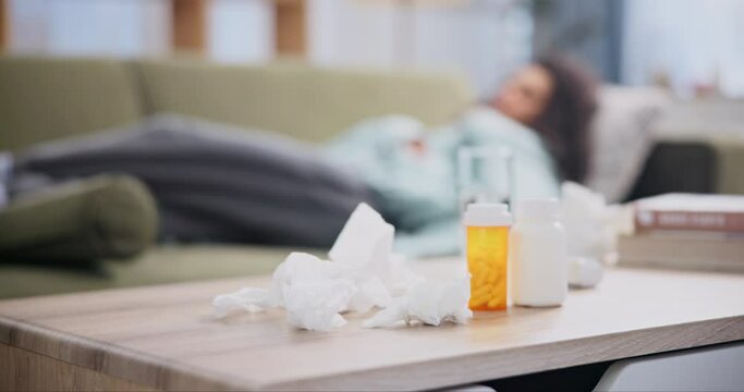 Pills, tissue and woman on sofa with water for hay fever, allergy or virus in living room. Female person, medicine and sick on couch with blanket for headache, covid 19 or flu infection at home