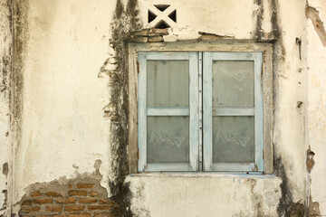 Fototapeta na wymiar Old wooden window in with old broken wall, dirty