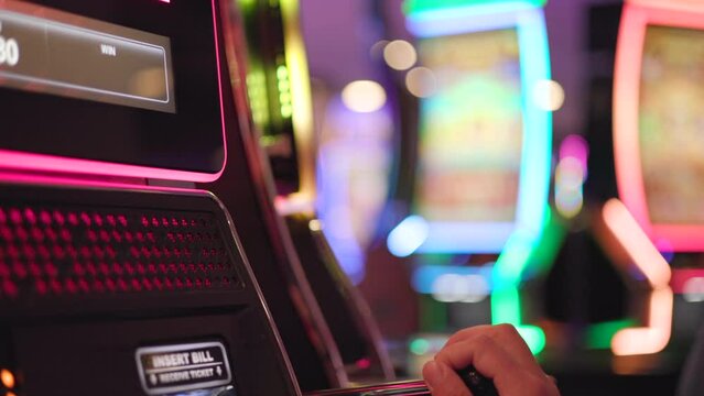 Caucasian Man in his 30s Playing Classic Slot Machine Game Inside One of the Las Vegas Casino. Colorful Gambling Industry Theme. One Armed Bandits