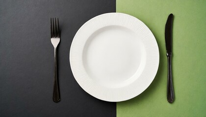 Empty wite plate on black and green pastel background. Top view with copy space. 