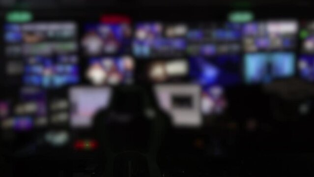 A blurry News TV studio station, live view screens with workers watching all the monitors changing their pictures. Slow motion, Hi Quality 4K footage 