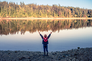 Fototapeta na wymiar Happy child on the lake feeling joyful a free in nature setting 