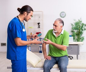 Fototapeta premium Old man visiting young male doctor gastroenterologist