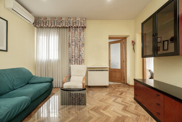Fototapeta na wymiar A living room in a house with dark wood furniture, varnished oak parquet floors and a large window with curtains and curtains