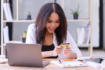 A young female buys things online or pays her bills by credit card through your computer.