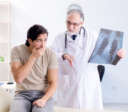 Young man visiting old male doctor radiologist