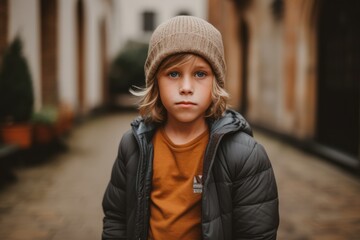 Portrait of a cute little boy in a hat on the street