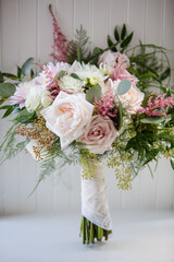 Beautiful Pink and White Monochromatic Cascading Modern Wedding Bouquet of Flowers with Soft Fern and Greenery in White Room against Window with Natural Light