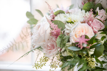 Beautiful Pink and White Monochromatic Cascading Close up of Modern Wedding Bouquet of Flowers with Soft Fern and Greenery in White Room against Window with Natural Light