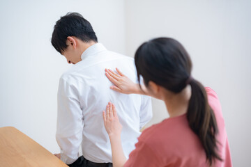 背中の痛みを訴える患者と診察する医師