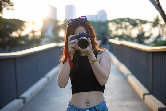 Photographer asian woman take outdoor photo with camera in city public urban park