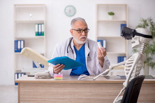 Old male doctor examining skeleton in the clinic