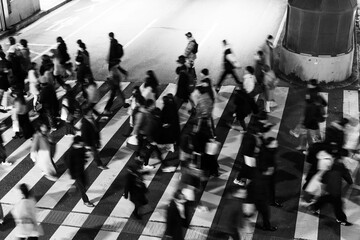 大都会の夜の横断報道を渡る人々をスローシャッターでぶらせて撮影。大阪梅田で。