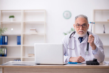 Old male doctor neurologist sitting in the clinic