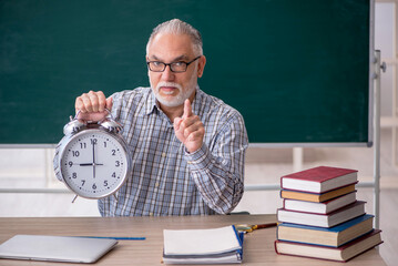 Old male teacher in time management concept