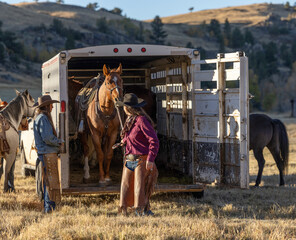 Two Cowgirls unloading a trailer on a wyoming ranch