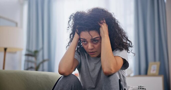 Woman, frustrated and depression on sofa in home with schizophrenia, mental health and burnout. Psychology, person and headache with anxiety, trauma and suffering on couch in living room with stress