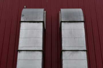 A/C ducts going into large red steel building.