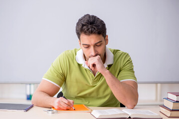 Young male student sitting in the classroom