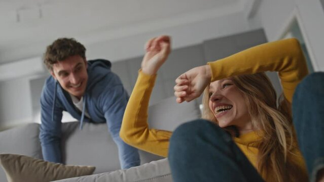 Laughing lovers having fun home closeup. Romantic happy couple fighting pillows