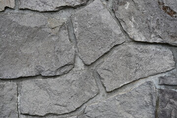 Gray stone wall, rough texture.