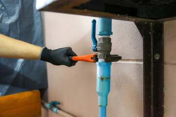 Technician plumber using a wrench to repair a water pump pipe. Concept of maintenance, fix water...