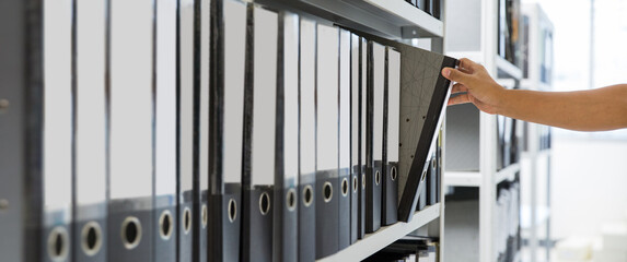 Hand of businessman office worker searching files and paperwork in the archive or document...