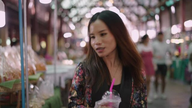 A beautiful asian woman smiles with her milkshake