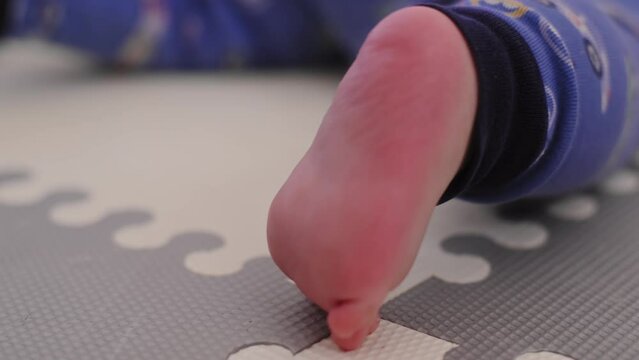 Baby boy's feet on the floor as he crawls