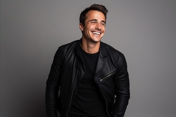 Portrait of a smiling young man in a black leather jacket.