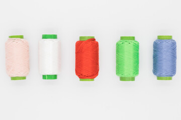 Colored spools of thread on a white background