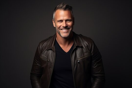 Portrait of a handsome mature man in leather jacket, smiling at camera.