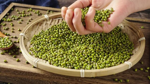 raw mung beans seeds in hand on table.	