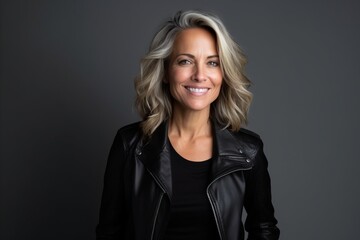 Portrait of a beautiful middle-aged woman in a black leather jacket - obrazy, fototapety, plakaty